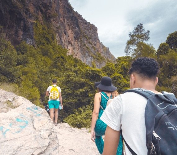 A group of hikers on a rocky trail through the green Akchour gorge in Morocco's Rif Mountains