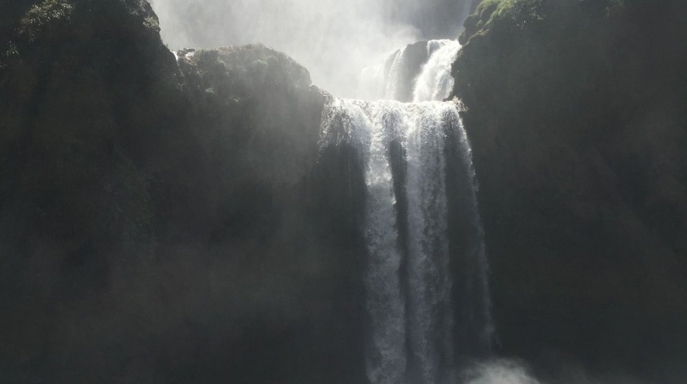 Tourists on a small raft at the base of the Ouzoud Waterfalls in Morocco
