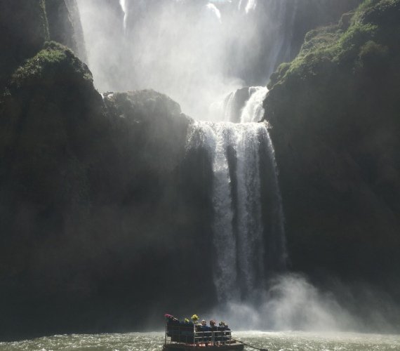 Tourists on a small raft at the base of the Ouzoud Waterfalls in Morocco
