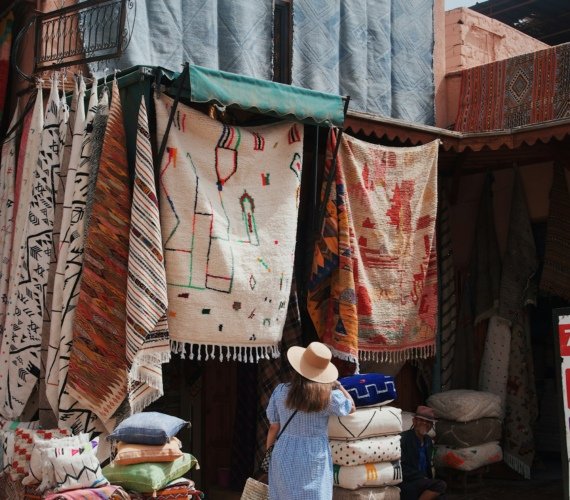 A woman in a sun hat browsing the goods outside a shop in the Marrakech souks