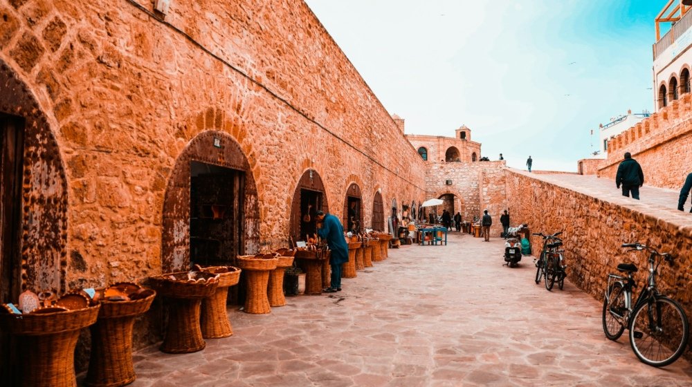 Visitors walking along the historic stone sea ramparts of Essaouira, Morocco