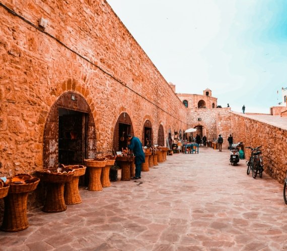 Visitors walking along the historic stone sea ramparts of Essaouira, Morocco